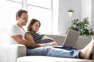 home loan refinance,debt consolidation home loan, paying debts off with home loan,gold coast, brisbane, qld, couple on couch with laptop, home loans, mortgage, first home buyers, deciding on a home loan, fhog, investing in property, comparing home loans,