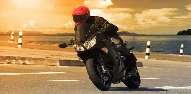 Motorcycle rider on a black bike at sunrise – compare motorbike loans Australia-wide for new, used, sports, cruiser, ATV and quad bikes.