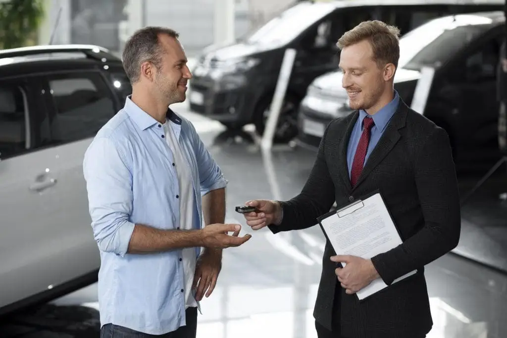 Gold Coast business owner reviewing business car loan paperwork beside a commercial vehicle for small business finance.